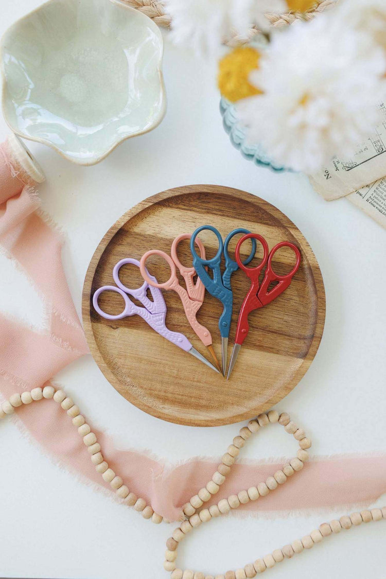 Stork embroidery scissors shown with an embroidery project — collectible bird-shaped scissors