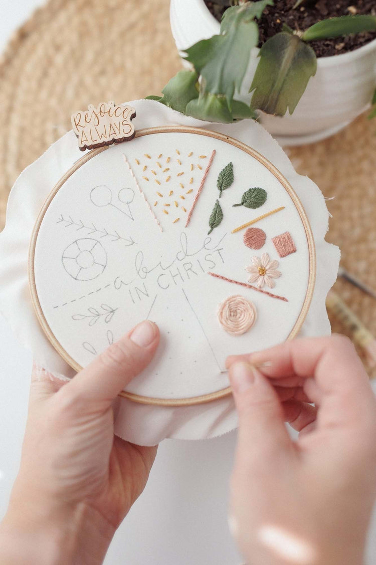 Stitching the 17-stitch practice sampler by hand, several stitches complete