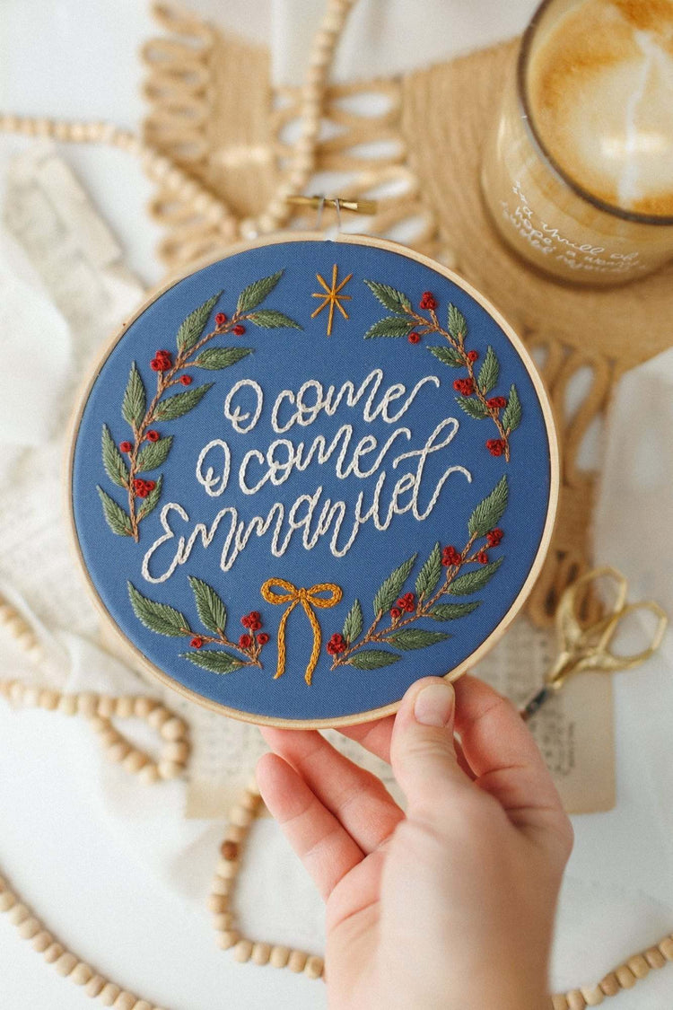 Hand holding the finished O Come O Come Emmanuel hoop to show scale