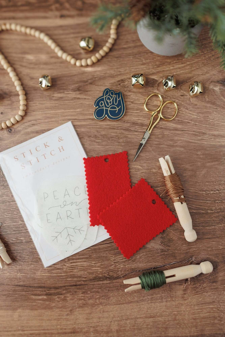 Peace on Earth stick and stitch sheets with red fabric and floss