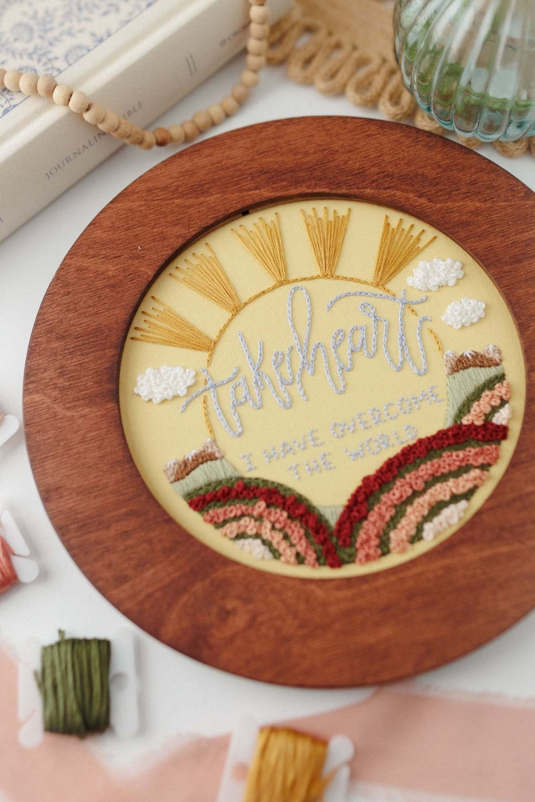 Finished Take Heart embroidery displayed in a walnut hoop frame