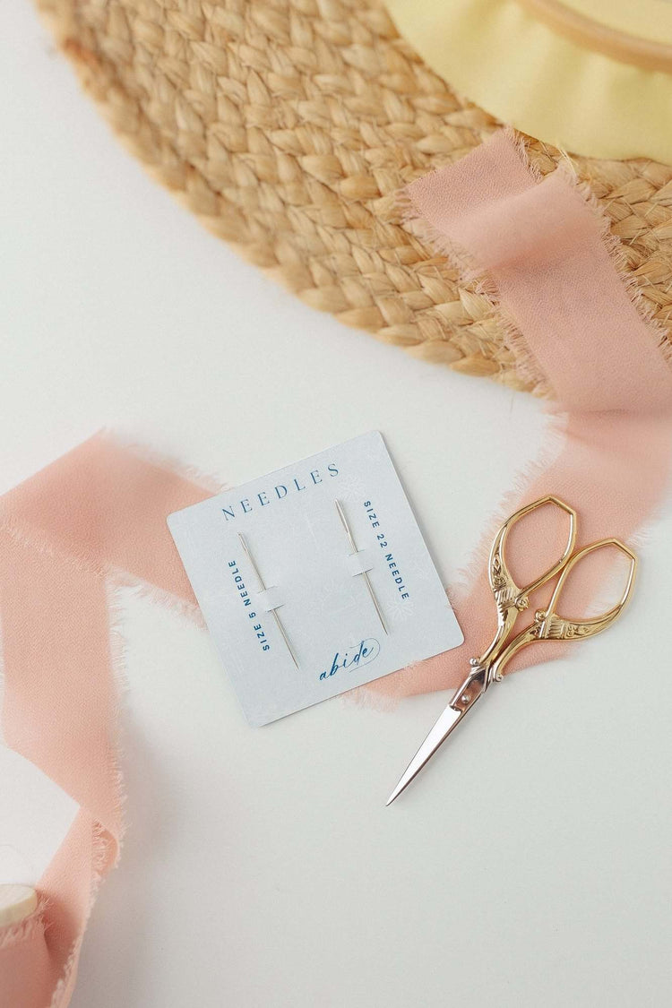 DMC embroidery needles with blush ribbon and embroidery scissors