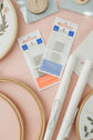 DMC needle packs, rolled Snow fabric and extra 6-inch hoops from the starter kit