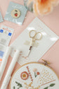 Strawberry needle minder, gold embroidery scissors and Snow fabric with the practice hoop