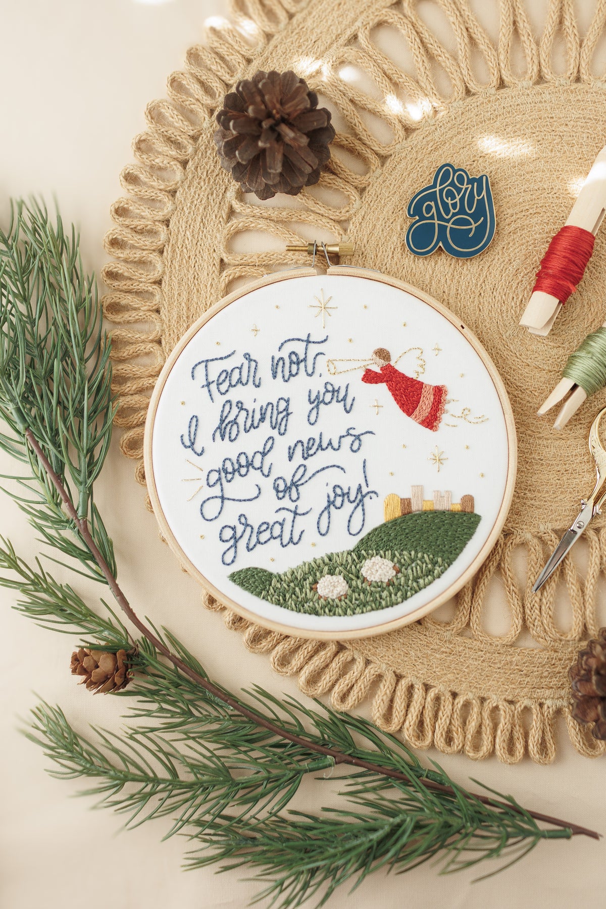 Finished Good News of Great Joy hoop with pine branches, pinecones and floss