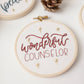 Close-up of the Wonderful Counselor ornament stitched in deep red with gold stars