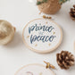 Close-up of the Prince of Peace ornament stitched in navy with gold stars