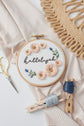 Hallelujah floral embroidery hoop with gold scissors and navy floss