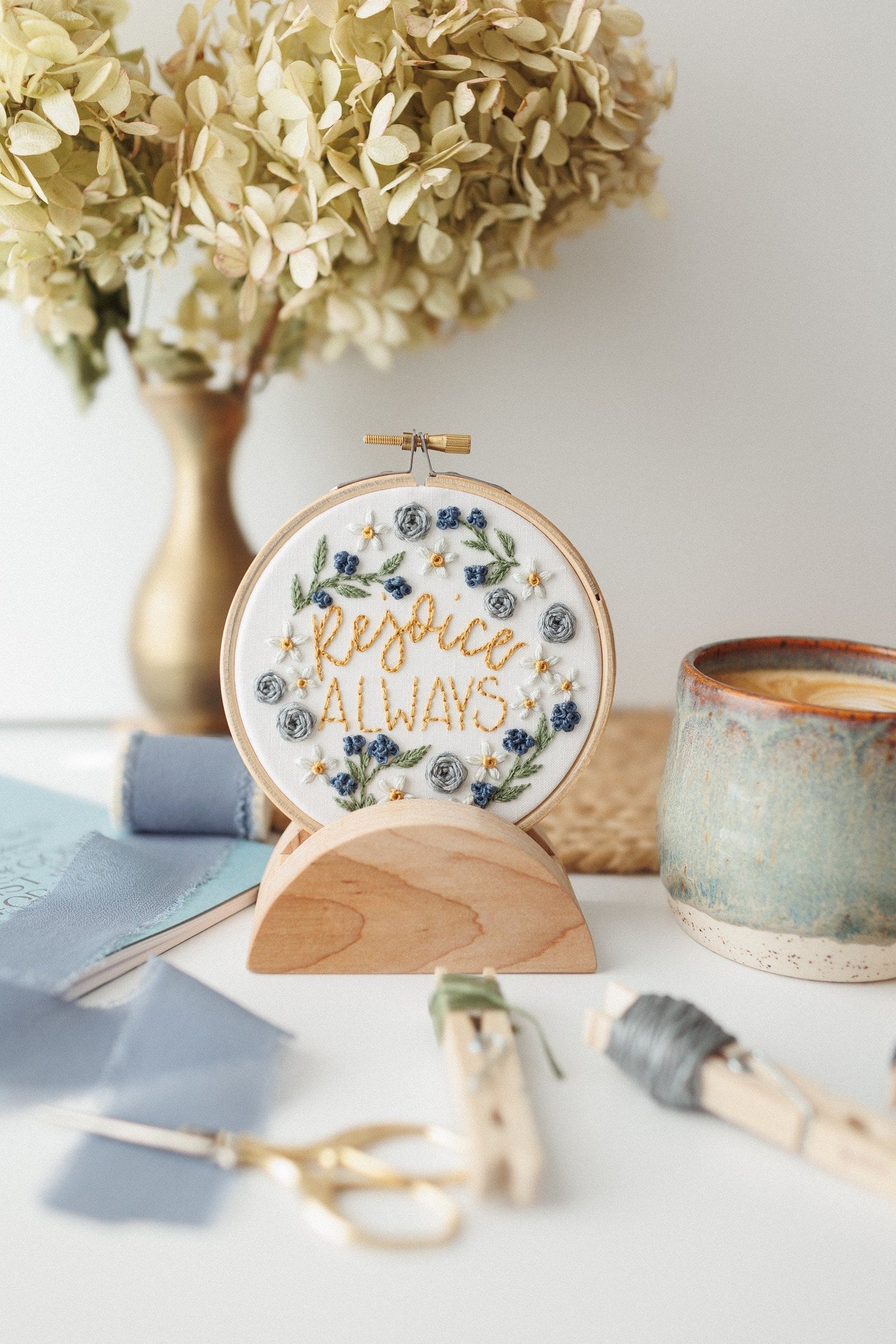 Rejoice Always hoop displayed as decor with pottery and dried florals