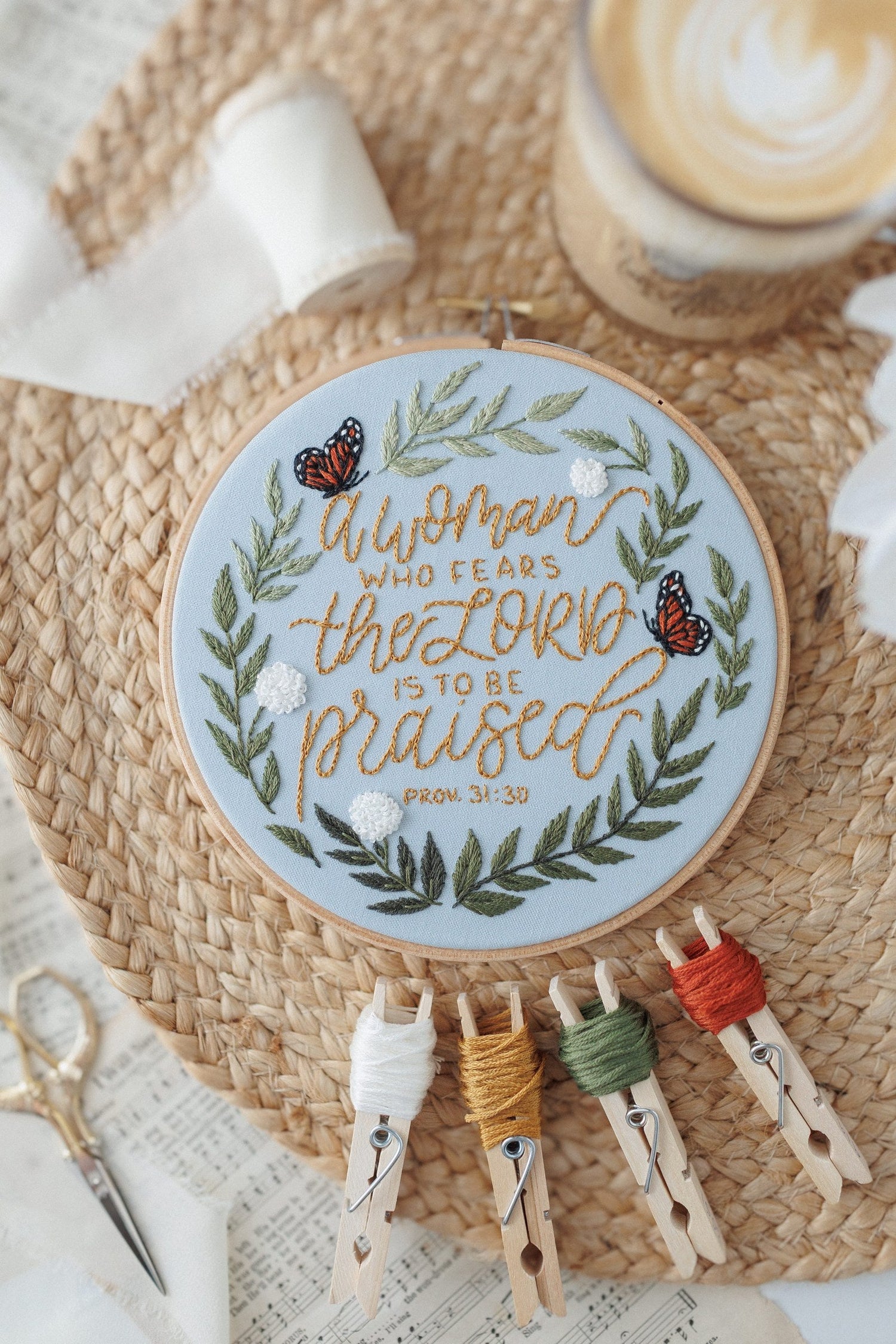 Proverbs 31 embroidery hoop with floss bobbins on a woven placemat
