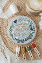 Proverbs 31 embroidery hoop with floss bobbins on a woven placemat