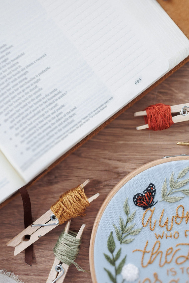 Proverbs 31 embroidery kit laid out beside an open Bible