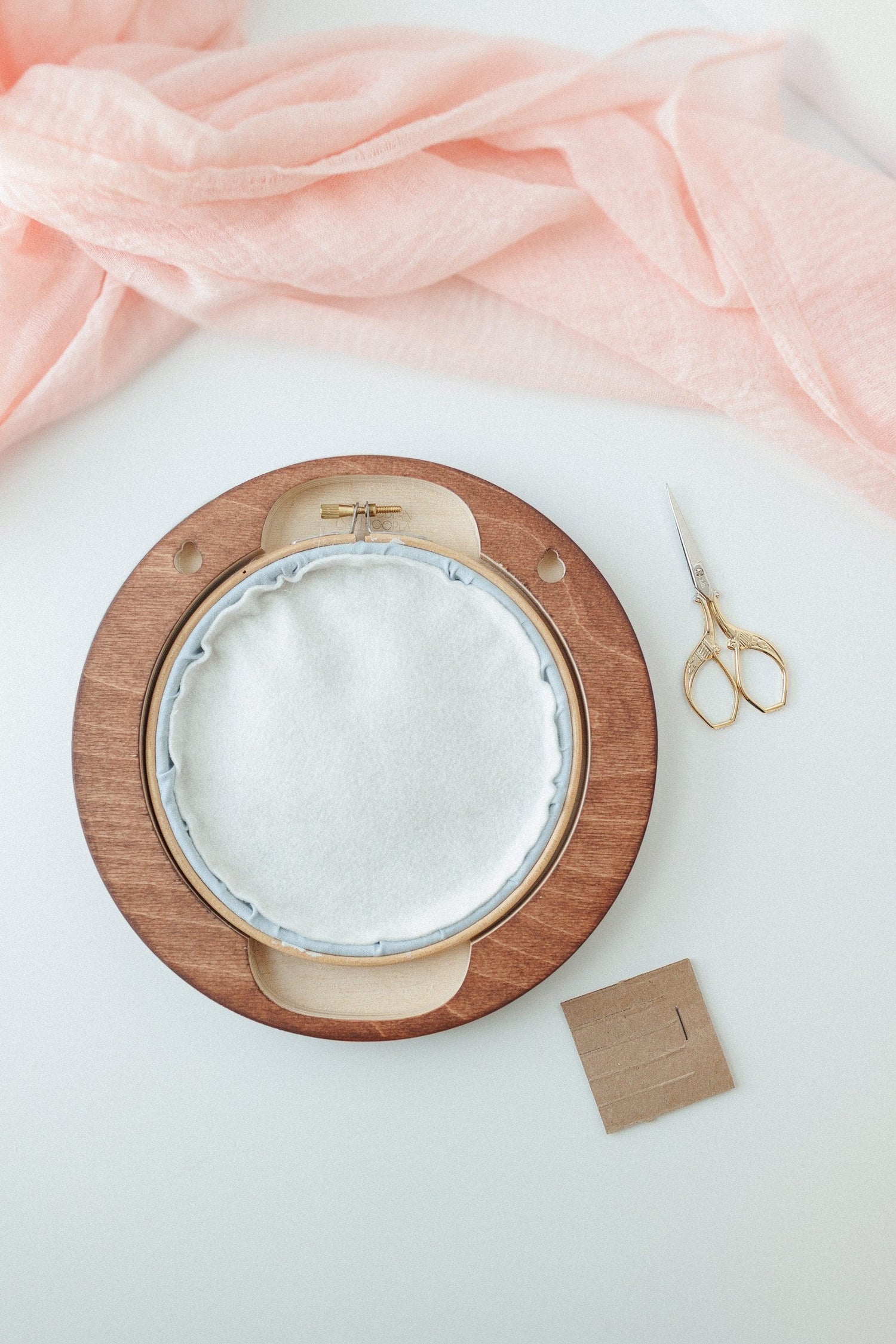 Pre-cut felt backing being fitted into a wooden hoop frame