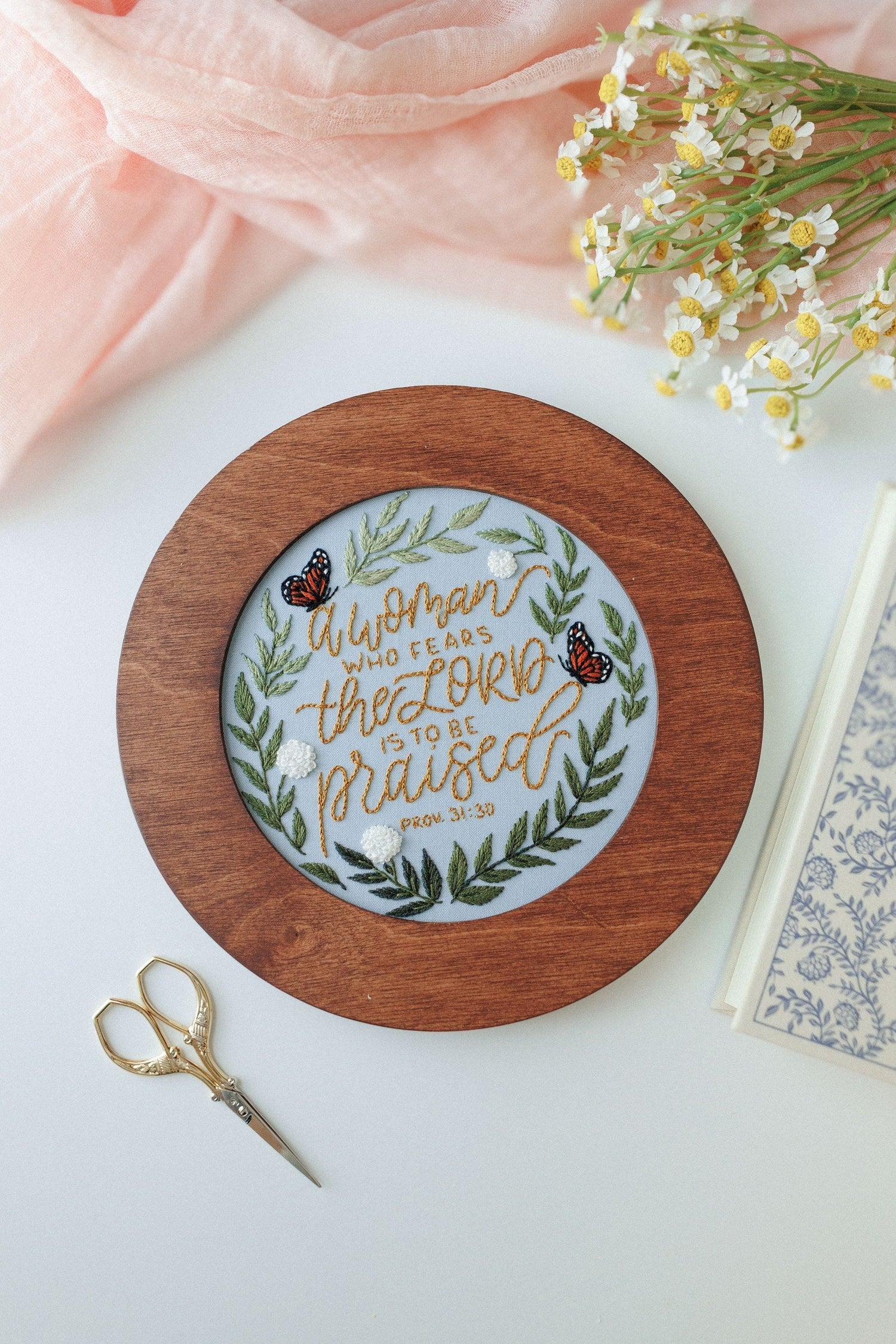 Finished Proverbs 31 piece displayed in a walnut hoop frame