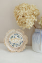Finished Rejoice Always piece beside a vase of dried hydrangea