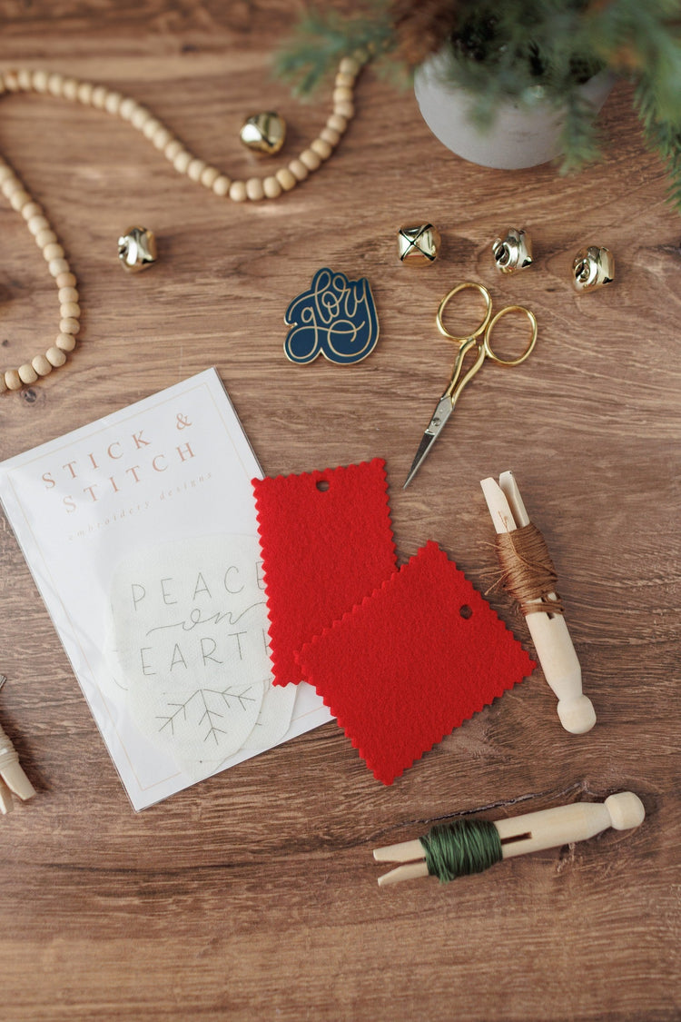 Peace on Earth stick and stitch sheets with red fabric and floss