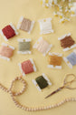 Take Heart kit contents — DMC embroidery floss bobbins, wood beads and gold scissors