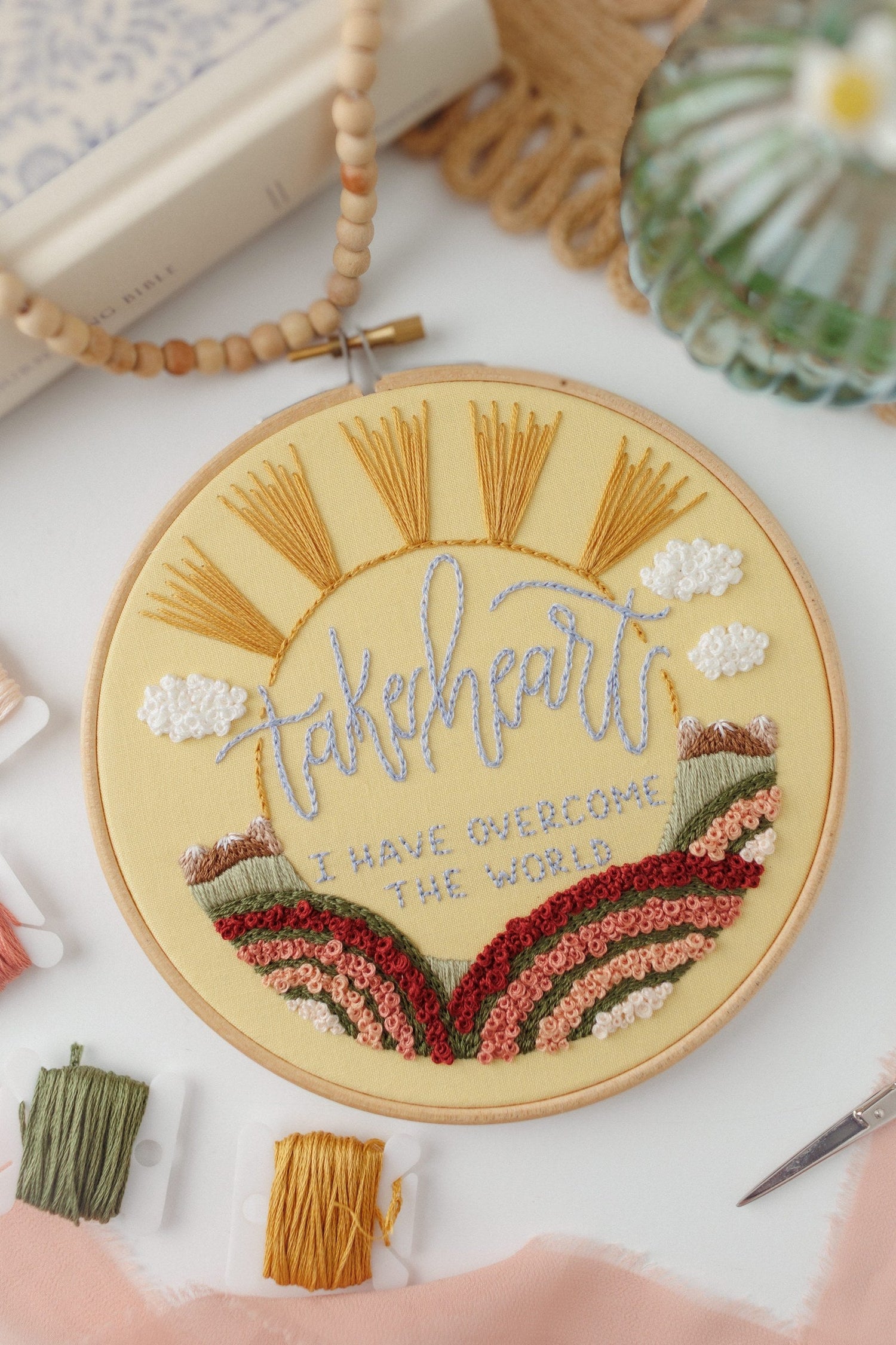 Close-up of the Take Heart sunrise and rainbow stitching in French knots