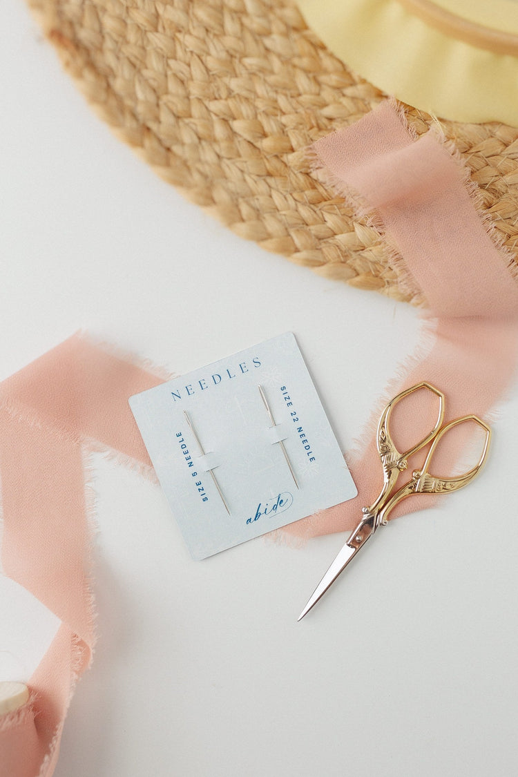 DMC embroidery needles with blush ribbon and embroidery scissors