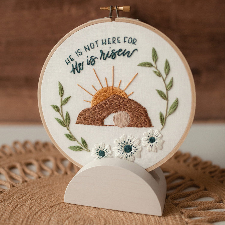 Finished embroidery hoop displayed on the wooden stand