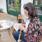 Embroidery hoop stand in use at a cafe table — hands-free stitching while seated