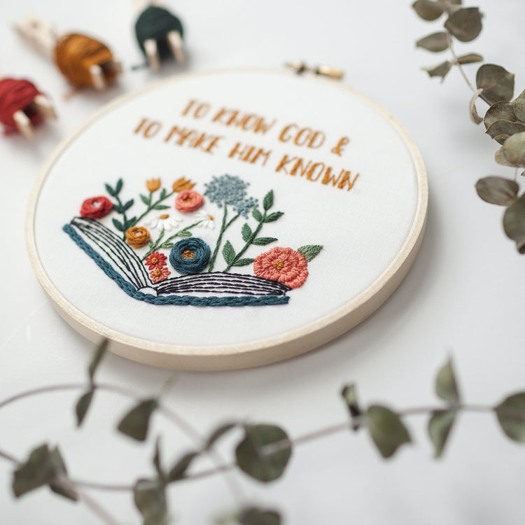Angled close-up of the open-book and wildflower embroidery detail