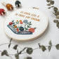 Angled close-up of the open-book and wildflower embroidery detail